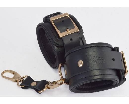 Черные кожаные наручники с золотистыми пряжками и карабином